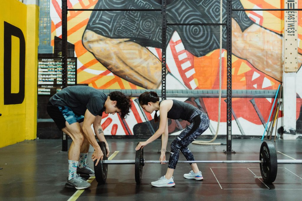 People putting weights on bar