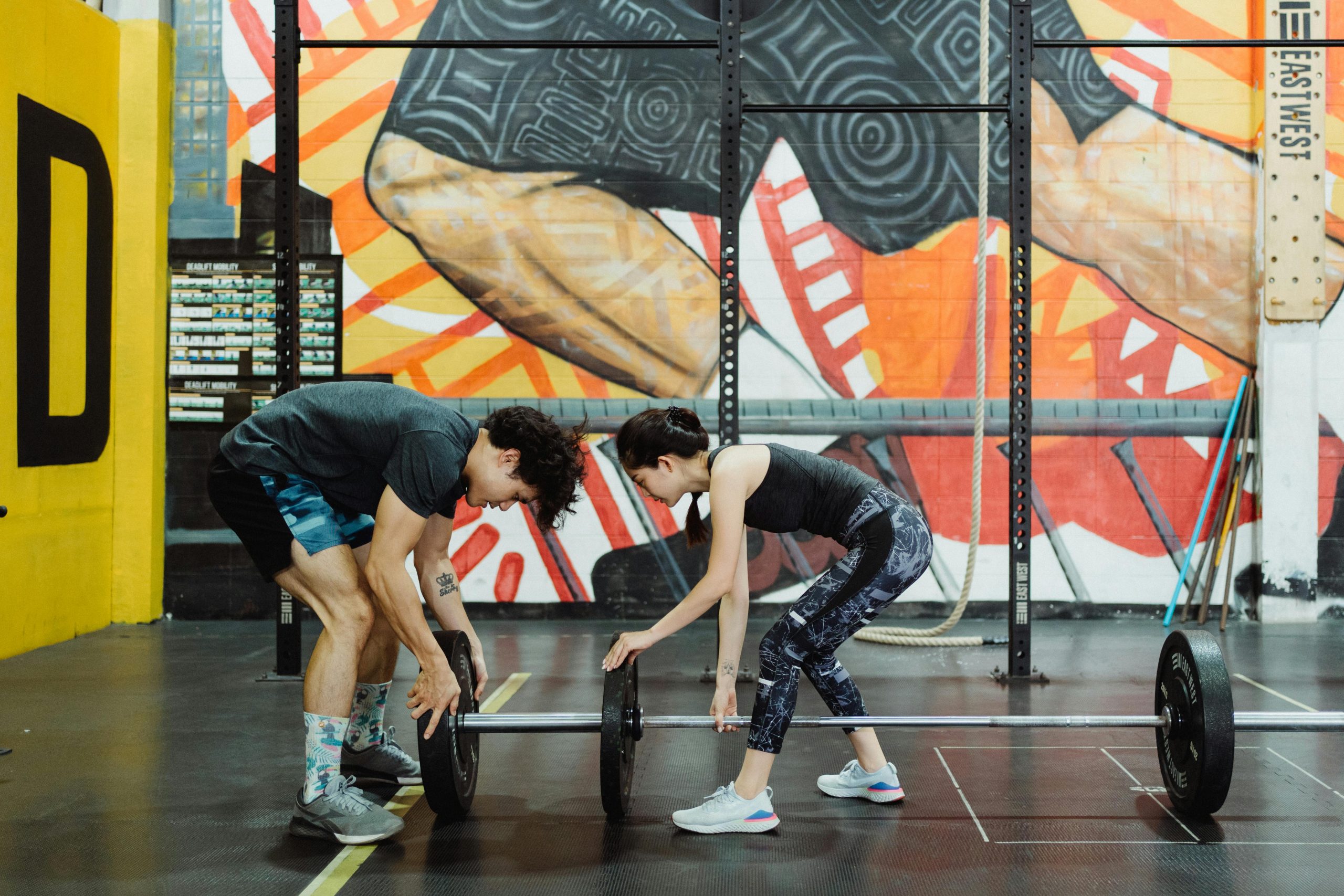 People putting weights on bar