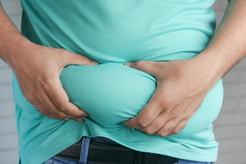Overweight man holding his belly