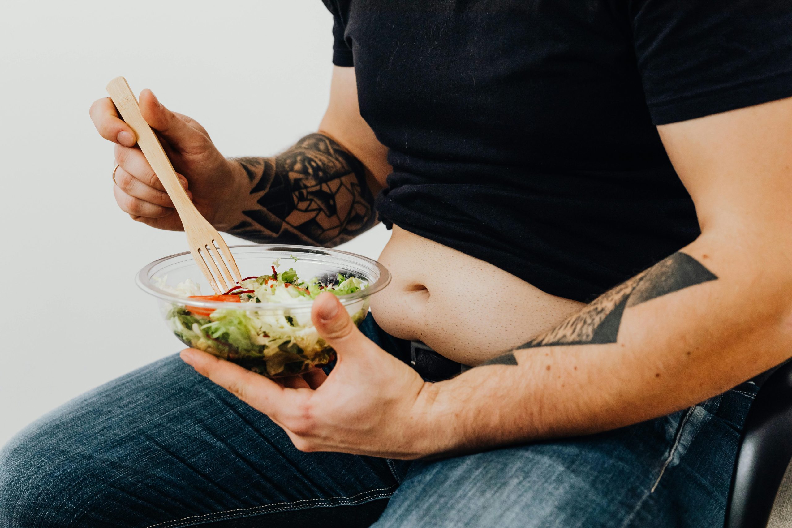 Man sitting down eating a salad