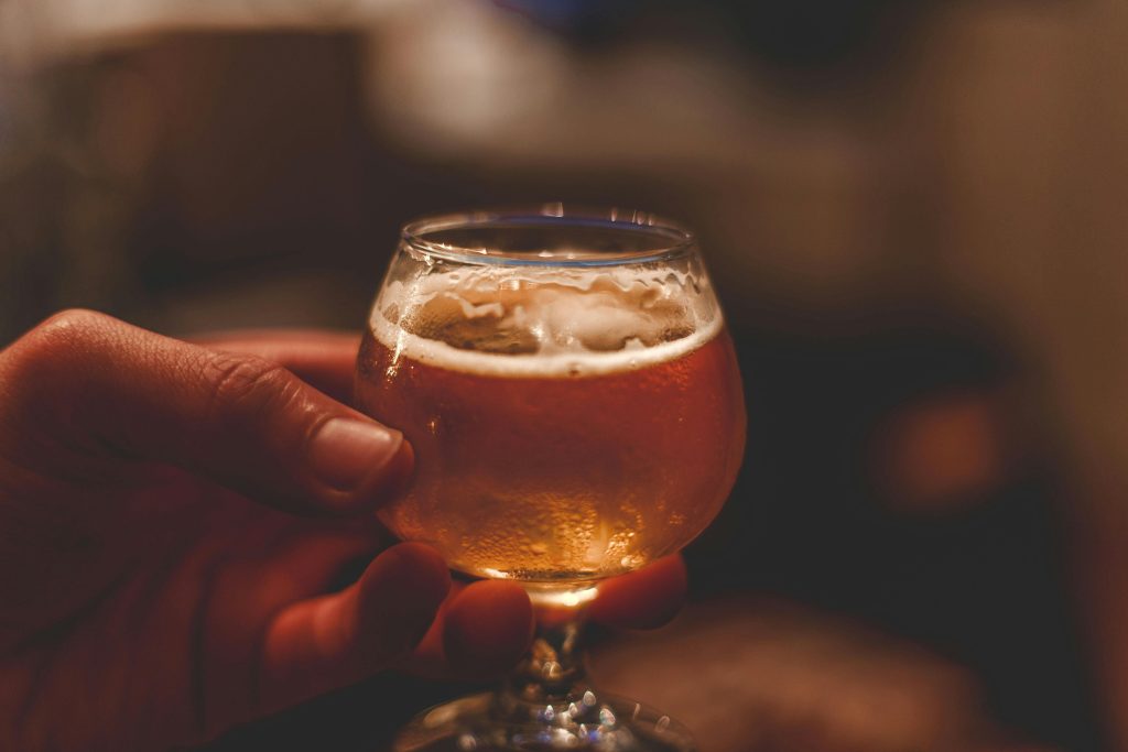 Person holding a glass of beer
